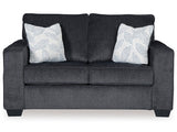 Ashley Furniture Altari Loveseat with plush upholstery and wooden legs, shown in a cozy living room setting.