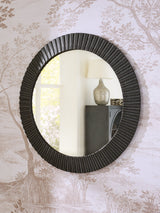 Ashley Furniture Ozias Accent Mirror hanging on a wall with a modern frame, ideal for living room or bedroom decor.