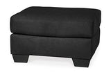 Ashley Furniture Darcy Ottoman featuring a soft fabric cushion and wooden legs in a modern design.
