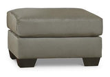 Ashley Furniture Darcy Ottoman featuring a plush fabric upholstery and a sturdy wooden base, ideal for living room decor