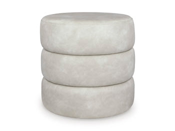 Ashley Furniture Ummi Swivel Accent Ottoman with plush fabric and modern design, shown in a cozy living room setting.