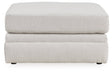 Ashley Furniture Adda Ottoman with plush fabric, featuring a soft, cushioned top and wooden legs for versatile living room seating.