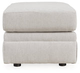 Ashley Furniture Adda Ottoman with cushioned top and wooden legs, serving as a stylish storage or footrest piece.