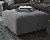 Ashley Furniture Ambee oversized accent ottoman with plush fabric and sturdy wooden legs, perfect for living room decor.