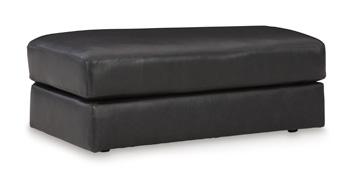 Ashley Furniture Amiata Ottoman featuring a plush fabric top and wooden legs, ideal as a versatile living room accent piece.