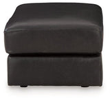 Ashley Furniture Amiata Ottoman in neutral fabric with wooden legs, showcasing a stylish and versatile accent piece for living rooms.