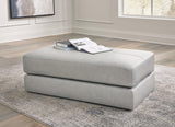 A plush oversized accent ottoman by Ashley Furniture with soft fabric upholstery and a modern design, shown in a cozy living room setting.