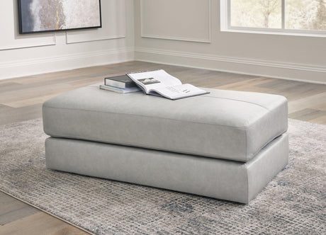 A plush oversized accent ottoman by Ashley Furniture with soft fabric upholstery and a modern design, shown in a cozy living room setting.