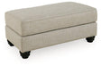 Ashley Furniture Asanti Ottoman with plush fabric and wooden legs, showcasing a stylish and comfortable accent piece for living rooms.