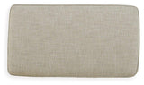 Ashley Furniture Asanti Ottoman with plush fabric and wooden legs, shown in a modern living room setting.