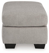 Avenal Park Ottoman by Ashley Furniture featuring a cushioned top and wooden legs in a neutral fabric finish.