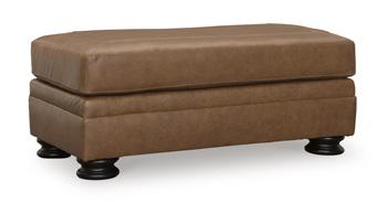Ashley Furniture Carianna Ottoman, plush fabric with tufted top and wooden legs, used as a stylish footrest or accent piece.