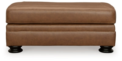 Ashley Furniture Carianna Ottoman with plush fabric and tufted top, shown from a front head-on perspective.