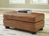 Ashley Furniture Carianna Ottoman in neutral fabric with wooden legs, showcasing a stylish and versatile living room accent piece.