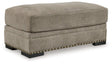 Ashley Furniture Galemore Ottoman showing plush fabric upholstery and wooden legs, ideal for living room decor.