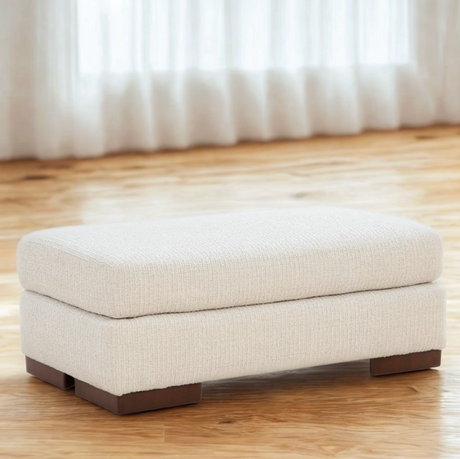 Ashley Furniture Jamestown Ottoman with upholstered fabric and wooden legs, shown in a cozy living room setting.