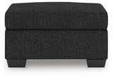 Ashley Furniture Jasmine Peaks Ottoman with plush fabric and wood legs, shown from a front head-on view.