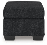 Ashley Furniture Jasmine Peaks Ottoman with fabric upholstery and wooden legs, shown from a side view.