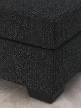 Ashley Furniture Jasmine Peaks Ottoman featuring beige fabric upholstery and wooden block legs.