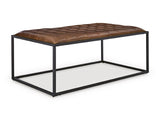 Ashley Furniture Junsor coffee table ottoman with a cushioned top and wooden legs, shown from an angled side view.