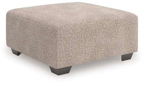 Ashley Furniture Newellen oversized accent ottoman with plush fabric and modern design, shown from an angled side view.