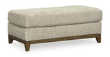 Ashley Furniture Parklynn Ottoman featuring a cushioned top and wooden legs, ideal for living room decor and extra seating.