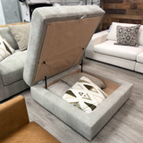 Ashley Furniture Riverview Ottoman with storage, showing a plush fabric upholstery and wooden legs, ideal for living room decor.