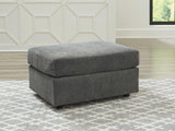 Ashley Furniture Stairatt Ottoman with plush fabric and storage space, shown in a cozy living room setting.