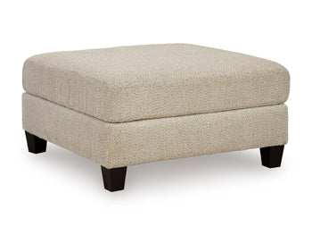 Ashley Furniture Steelwater Retreat oversized accent ottoman with plush fabric and wooden legs, shown from an angled view.