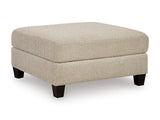 Ashley Furniture Steelwater Retreat oversized accent ottoman with plush fabric and wooden legs, shown from an angled view.