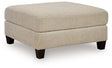 Ashley Furniture Steelwater Retreat oversized accent ottoman with plush fabric and wooden legs, shown from an angled view.