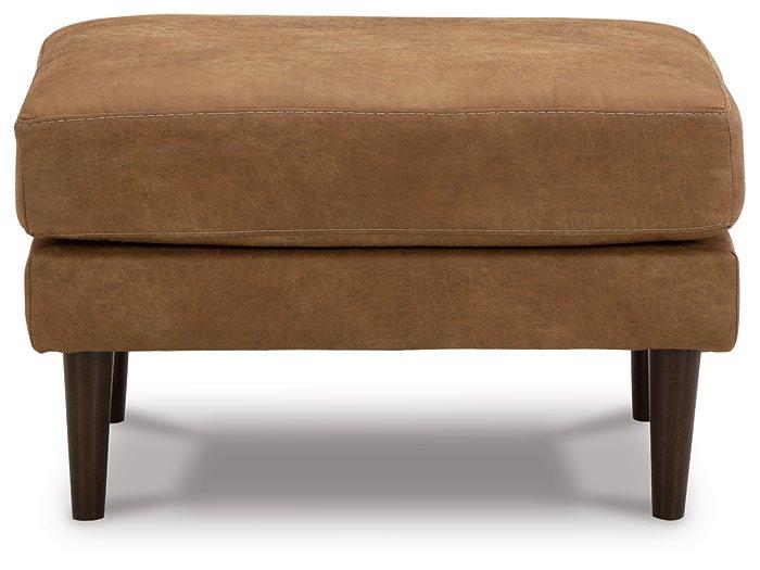Ashley Furniture Telora Ottoman with plush fabric and wooden legs, shown in a cozy living room setting.