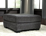 Oversized Ashley Furniture Tracling Ottoman with soft fabric upholstery and plush cushioning on a modern living room floor.