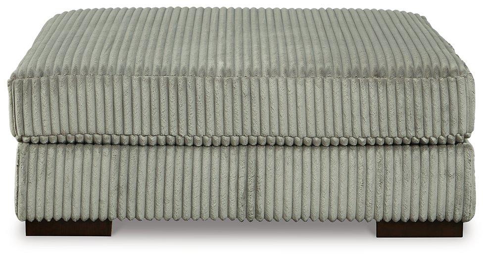 Ashley Furniture Lindyn oversized accent ottoman with plush fabric and modern design, shown in a cozy living room setting.