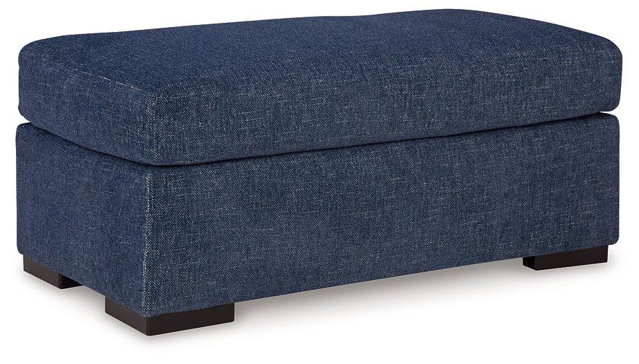 Ashley Furniture Evansley Ottoman showing a plush fabric surface and wooden legs, ideal for living room or bedroom decor.