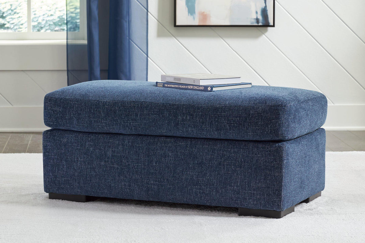 Ashley Furniture Evansley Ottoman in beige fabric with wooden legs, showcasing a plush, versatile storage and seating solution.