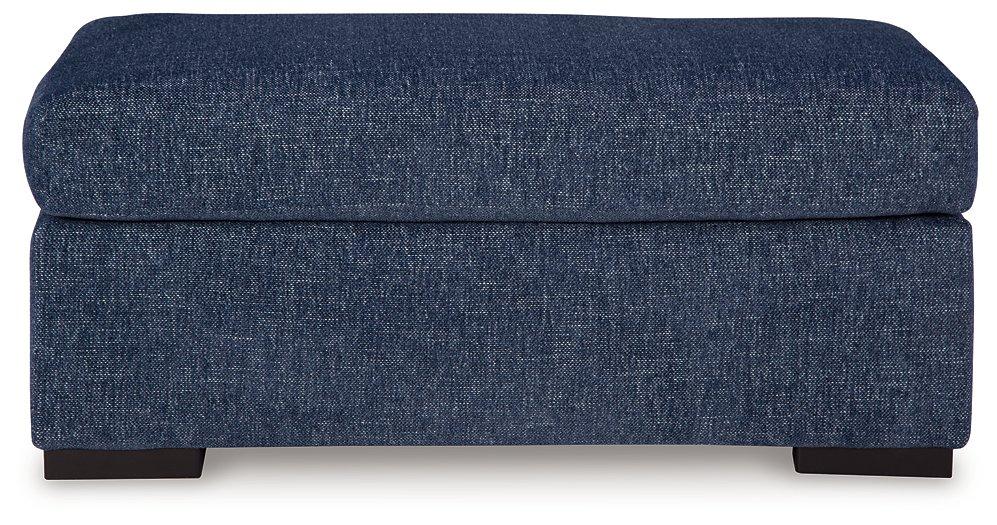 Ashley Furniture Evansley Ottoman with plush fabric and wooden legs, serving as a stylish and versatile living room accent piece.