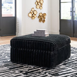 Oversized Midnight-Madness Ashley Furniture accent ottoman with plush fabric and modern design, shown in a cozy living room setting.
