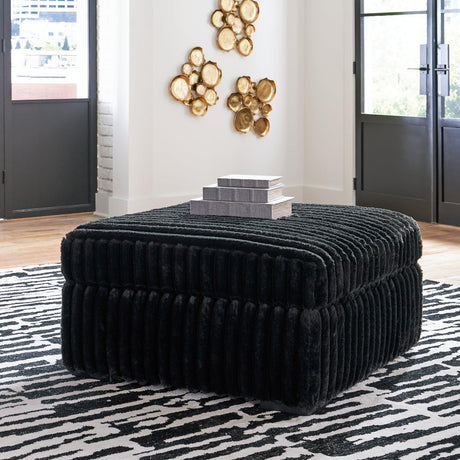 Oversized Midnight-Madness Ashley Furniture accent ottoman with plush fabric and modern design, shown in a cozy living room setting.