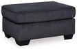 Ashley Furniture Altari Ottoman showing a stylish fabric-covered ottoman with wooden legs, ideal for living room decor.
