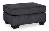 Ashley Furniture Altari Ottoman in neutral fabric with wooden legs, showcasing its compact design and versatile style.