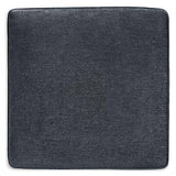 Oversized Ashley Furniture Altari accent ottoman with plush fabric and sturdy wooden legs sitting on a neutral-toned floor.