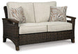 Outdoor loveseat from Ashley Furniture, Shoreside collection, featuring plush cushions and sturdy frame for outdoor relaxation.