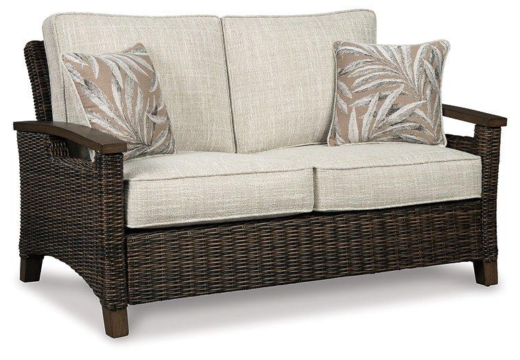 Outdoor loveseat from Ashley Furniture, Shoreside collection, featuring plush cushions and sturdy frame for outdoor relaxation.