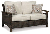 Outdoor loveseat from Ashley Furniture, Shoreside collection, featuring plush cushions and sturdy frame for outdoor relaxation.