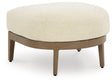 Outdoor Ashley Furniture Serene Bay ottoman with cushion, featuring woven design and plush seating for outdoor relaxation.