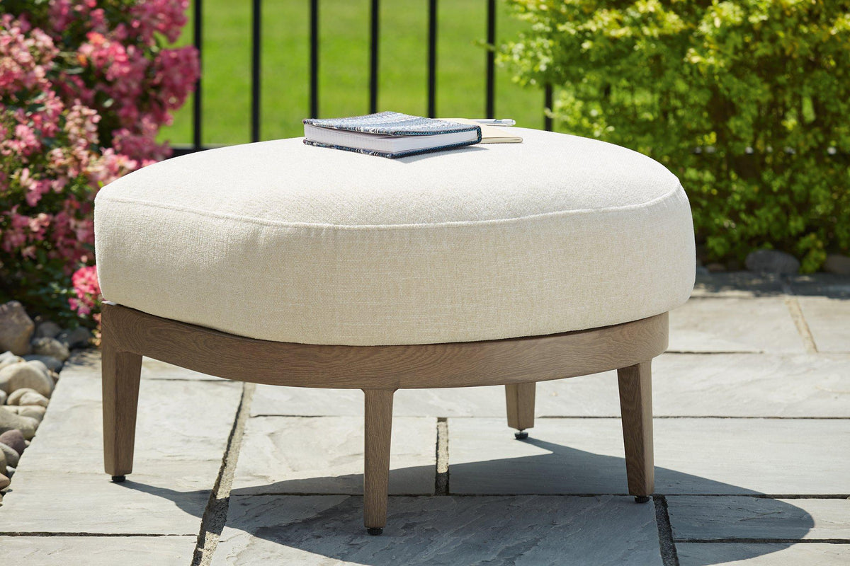 Outdoor Ashley Furniture Serene Bay Ottoman with cushion, featuring a woven design and plush seat for outdoor relaxation.