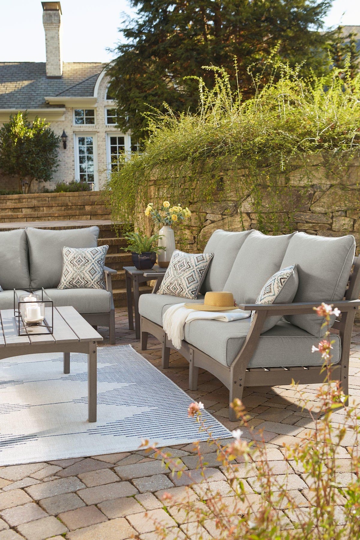 Ashley Furniture Visola outdoor sofa with beige cushions, weather-resistant outdoor seating for patio or garden use.