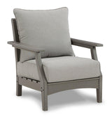 Ashley Furniture Visola outdoor loveseat conversation set with cushioned seats and a coffee table in a backyard patio setting.