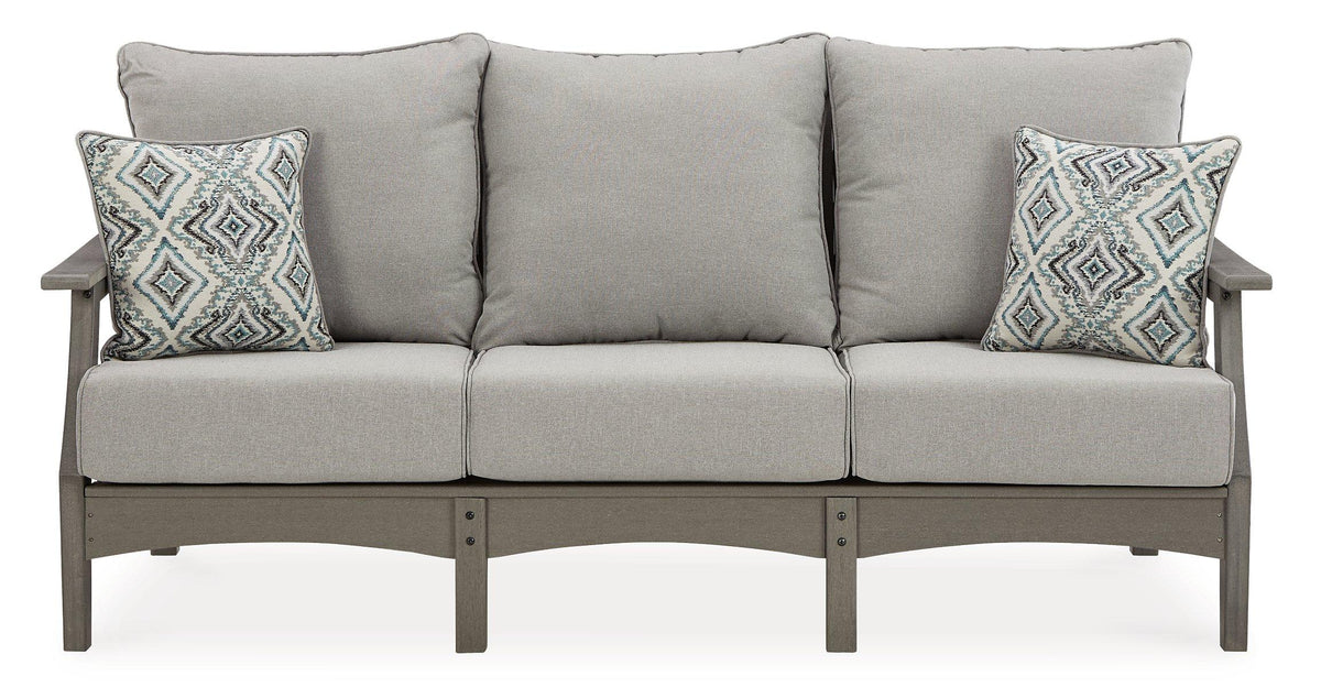 Outdoor Ashley Furniture Visola sofa and loveseat with coffee table in a cozy patio setting, featuring comfortable cushions and stylish design.
